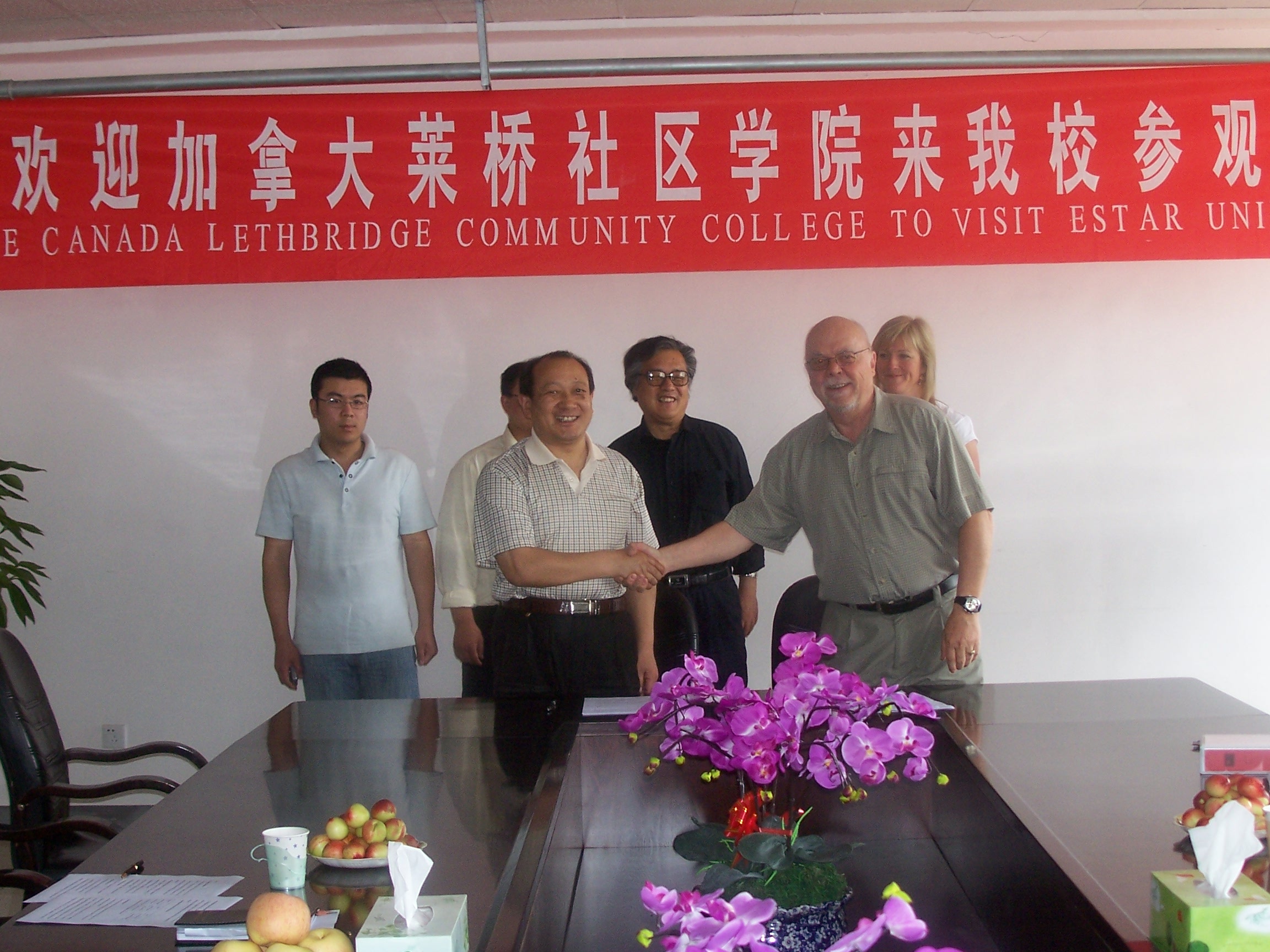 图为我校校长陈昌金先生向加拿大莱桥社区学院院长